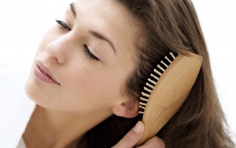 Portrait of a young woman brushing her hair --- Image by © A. Chederros/Onoky/Corbis